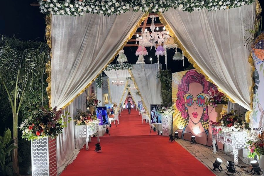 The walkway at night as a red-carpet corridor with tiered chandeliers.